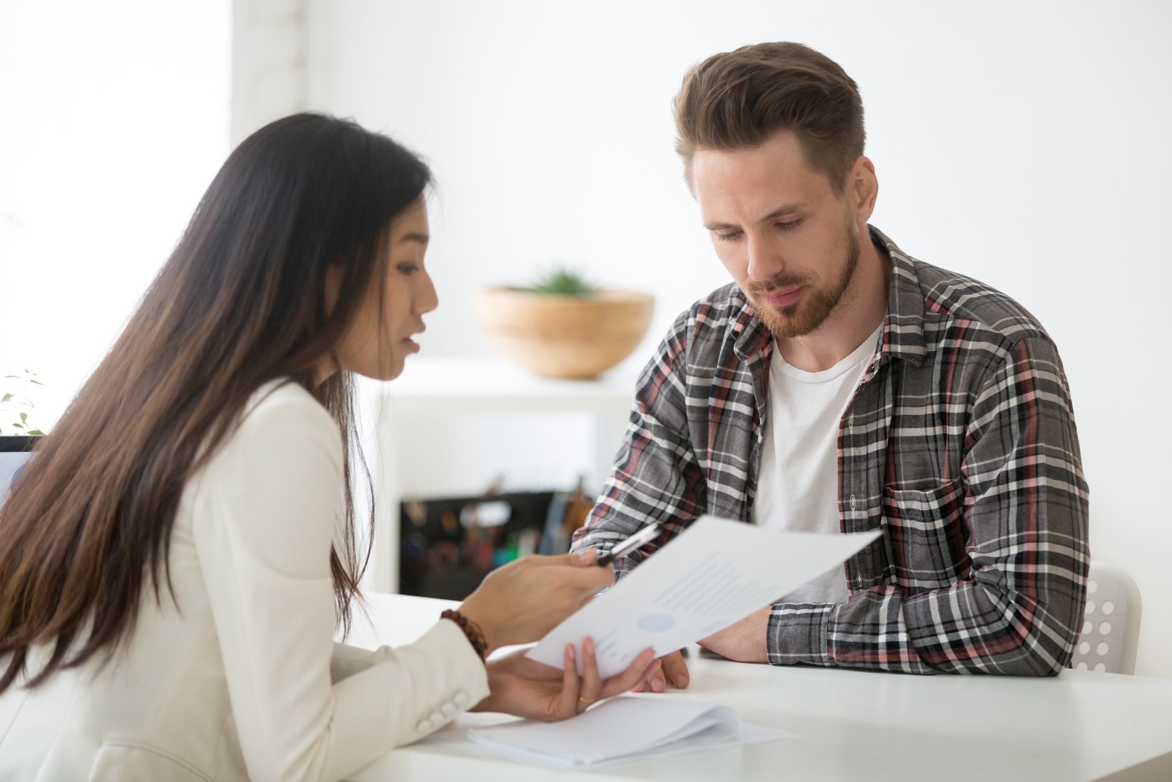 Female mentor coaching male employee on financial issues